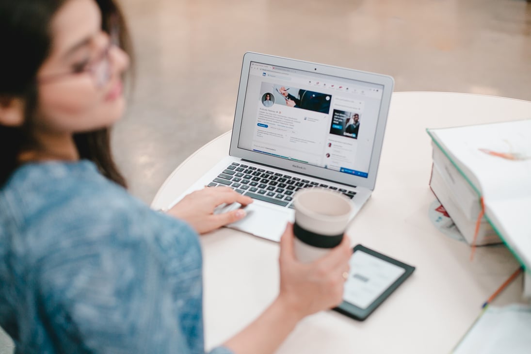 Woman in Blue and White Shirt using Laptop